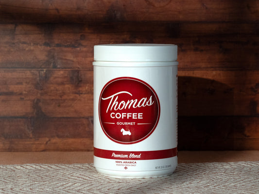 Thomas Coffee Premium Blend container with red label on a wooden background