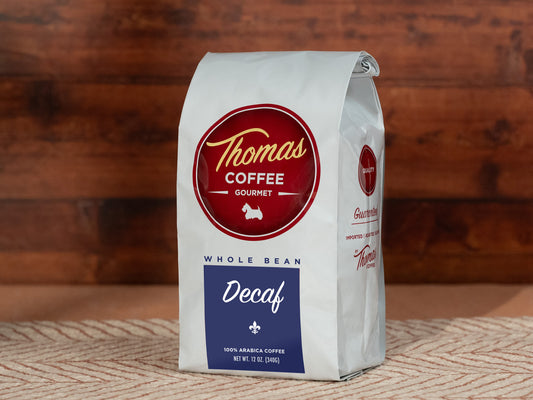 Thomas Coffee Gourmet Decaf whole bean coffee bag on a wooden surface
